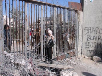 Un passage à travers une porte. Un barreau à été enlevé, mais les Israéliens ont installé des barbelés. - 47.1 ko Un passage à travers une porte. Un barreau à été enlevé, mais les Israéliens ont installé des barbelés. - 47.1 ko